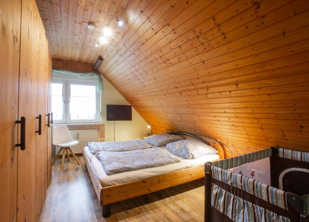 a bedroom with a bed in a wooden wall at Haus Schulze in Braunlage