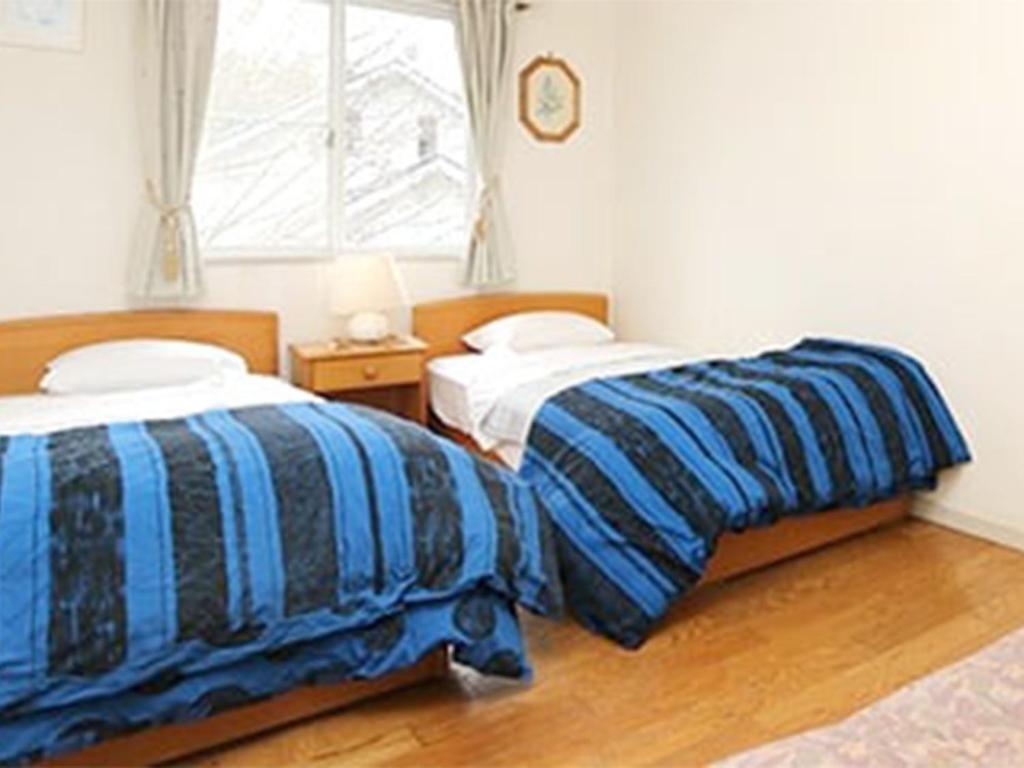 two beds sitting next to each other in a bedroom at Blanche Mori - Vacation STAY 86835v in Hokuto