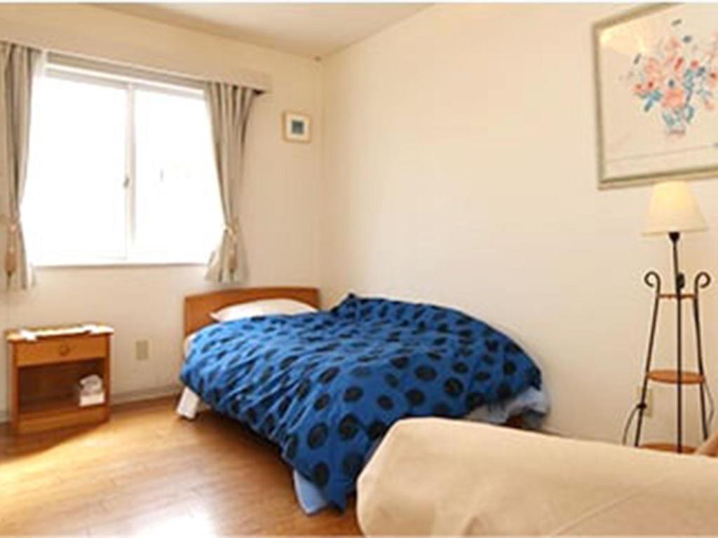 Un dormitorio con una cama azul y una ventana en Blanche Mori - Vacation STAY 86845v, en Hokuto