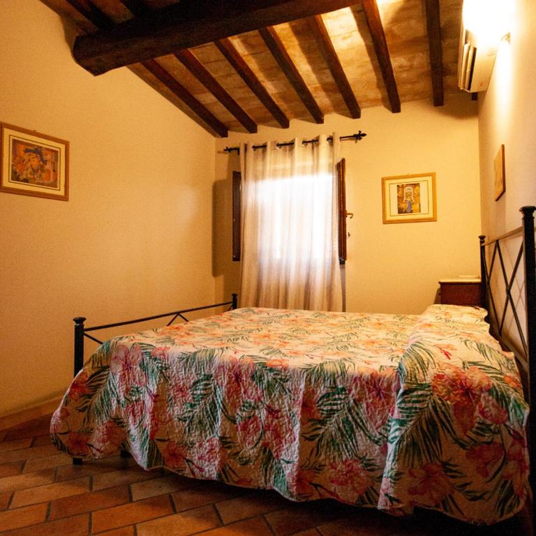 a bedroom with a bed in a room with a window at Lu Renge in Fiaiola