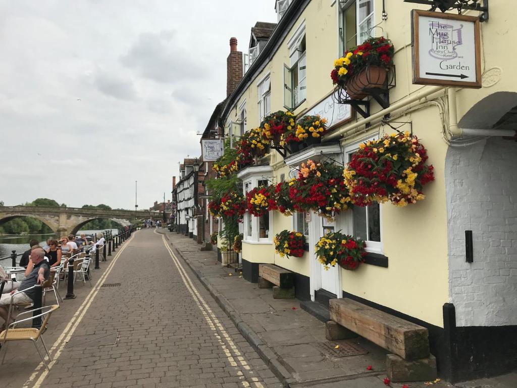 uma linha de edifícios com caixas de flores sobre eles em The Mug House Inn em Bewdley