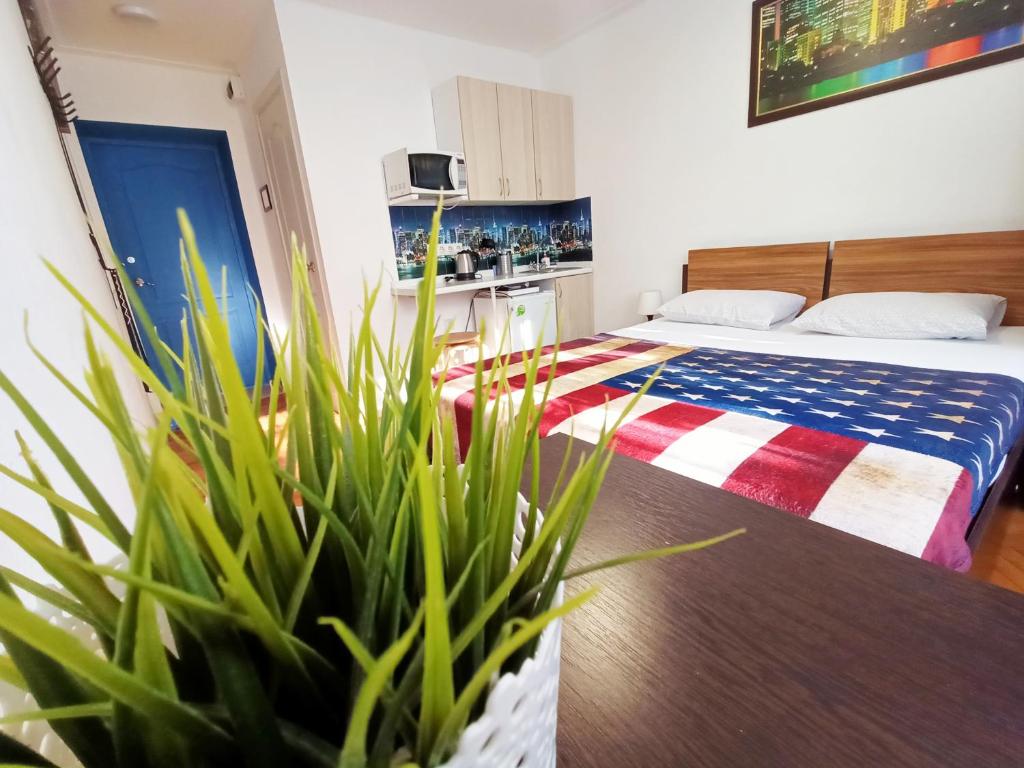 a hotel room with a bed and a potted plant at Tri stolitsy Apartment in Krasnodar