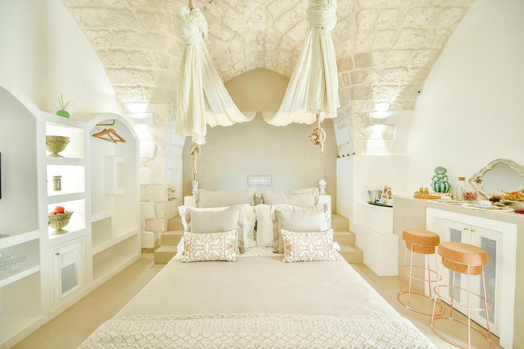 a bedroom with a large bed with white pillows at Eurydice Suite with Infinity Jacuzzi in Ostuni