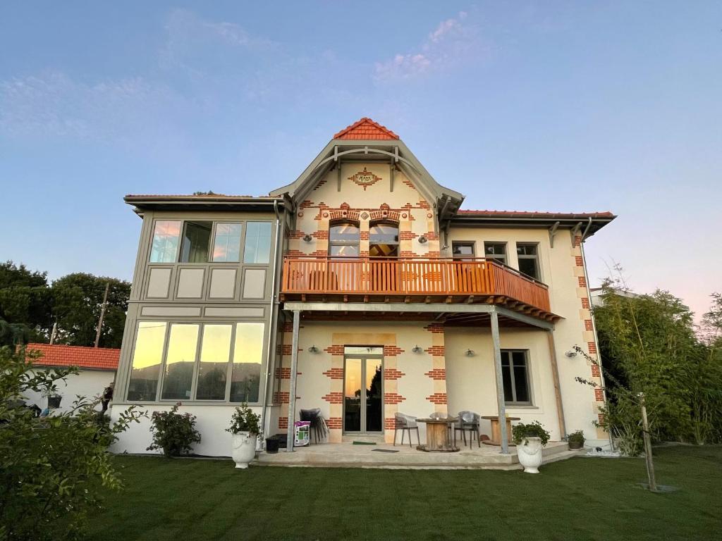 uma casa grande com uma varanda em cima em VILLA MADY em Andernos-les-Bains