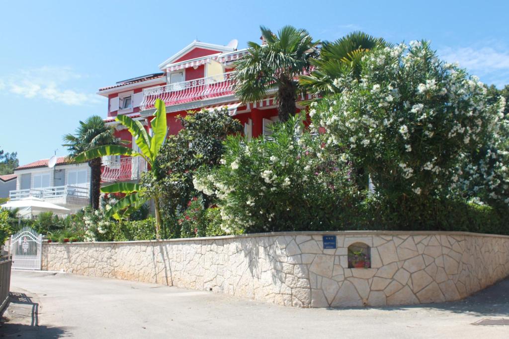 un muro di pietra con alberi e una casa sullo sfondo di Rooms Daria a Rovigno (Rovinj)