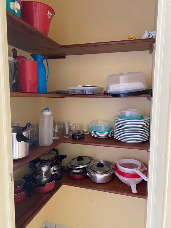 una dispensa con piatti e padelle e piatti su scaffali di Condomínio Portal do Paraíso a Lucena
