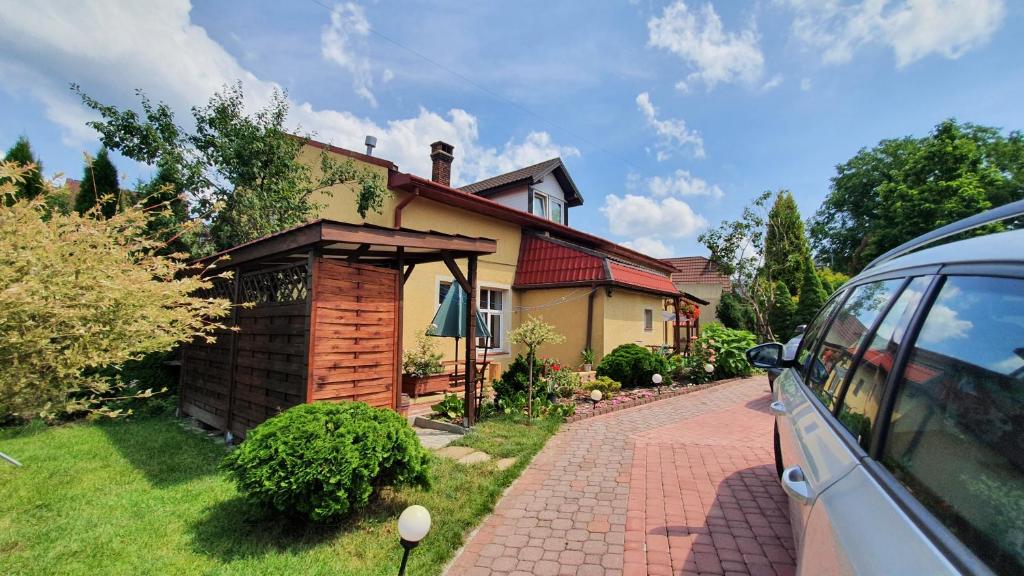 a house with a car parked in front of it at Brama Bieszczad in Lesko