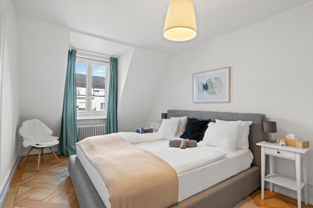 a bedroom with a large white bed and a window at Central Bright & Cozy Apartments in Luzern