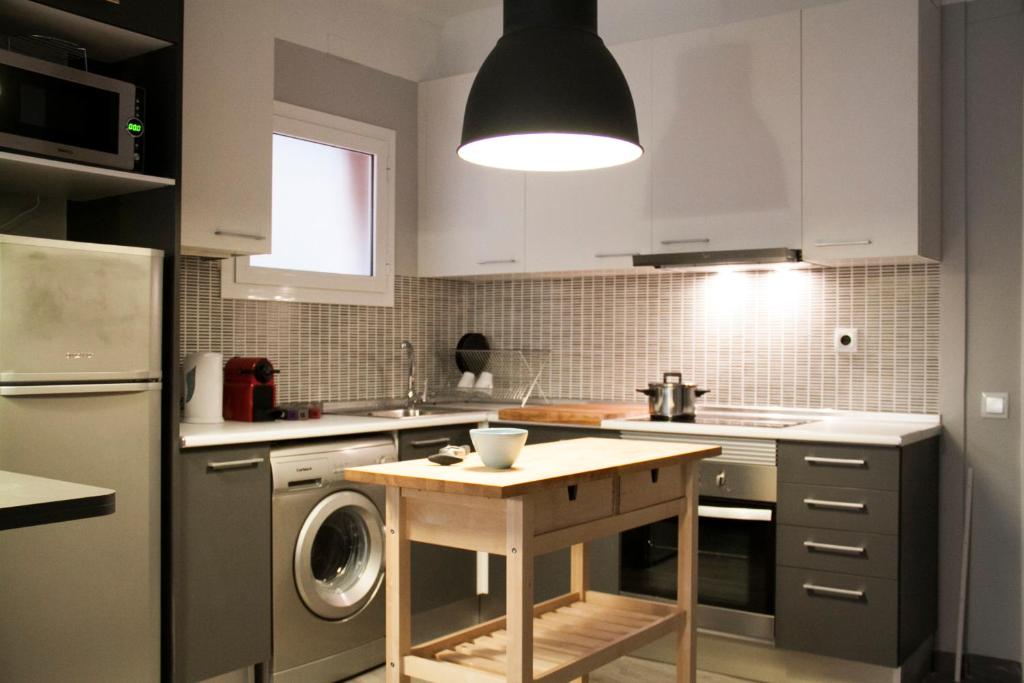 a kitchen with a table and a washing machine in it at Idyllic Apartment with Terrace in Barcelona