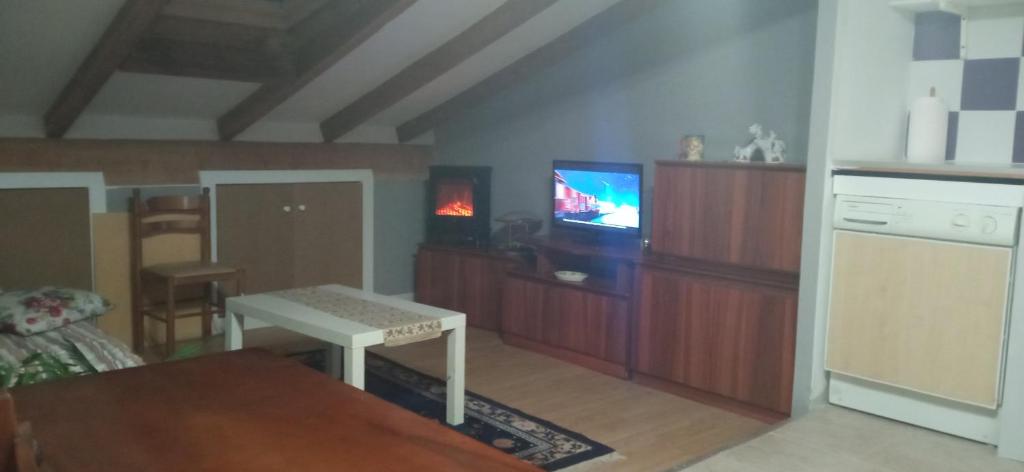 sala de estar con mesa y TV. en ático, en Laguardia