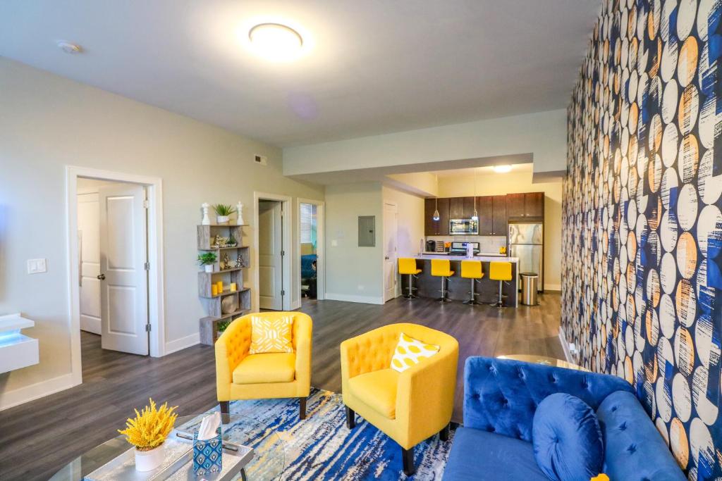 a living room with a blue couch and yellow chairs at Windy Heart Apartment in Chicago