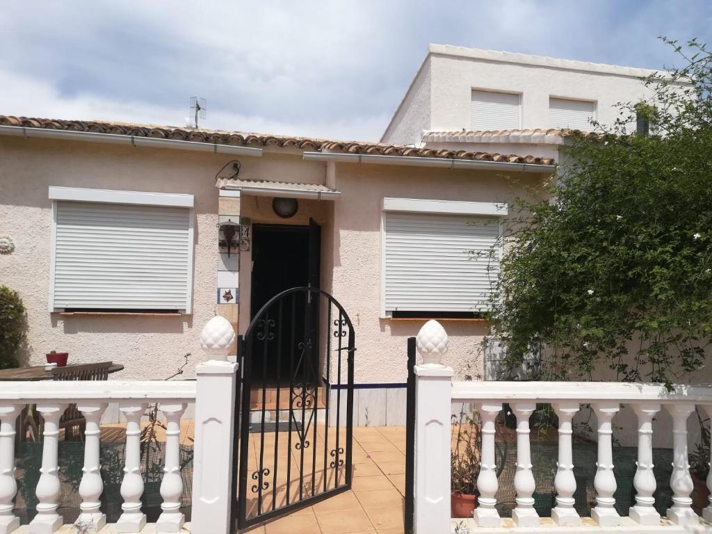 una casa con un cancello e una recinzione bianca di Bungalow cerca de la playa a Denia