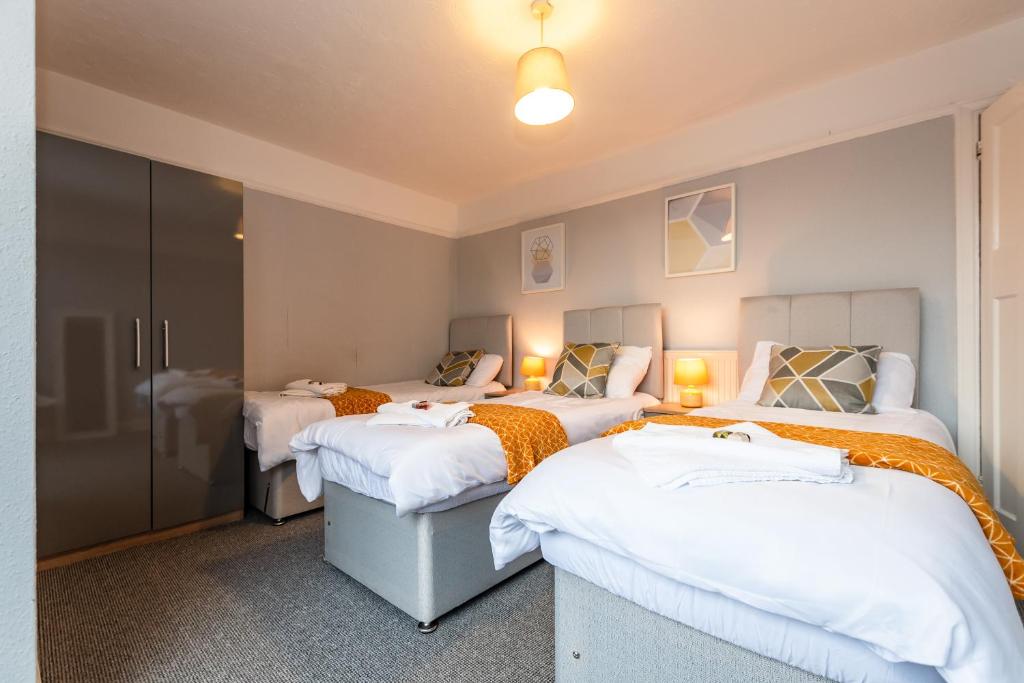 três camas num quarto com lençóis brancos em BEST PRICE! Perfect Gunwharf Accommodation - 5 single beds or Kingsize FREE PARKING em Portsmouth