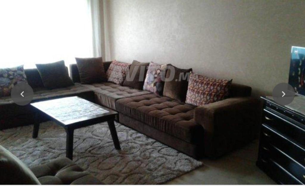 a living room with a couch and a table at Appartement à proximité de l'aéroport Mohamed V Casablanca in Nouaseur
