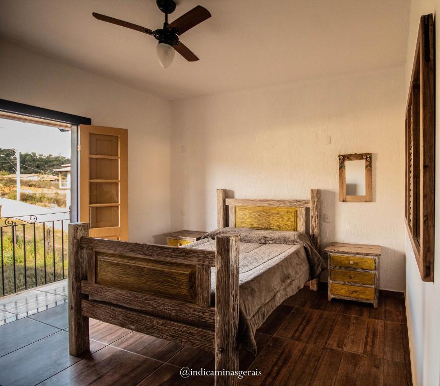 a bedroom with a bed and a ceiling fan at Pouso Tiradentes in Tiradentes