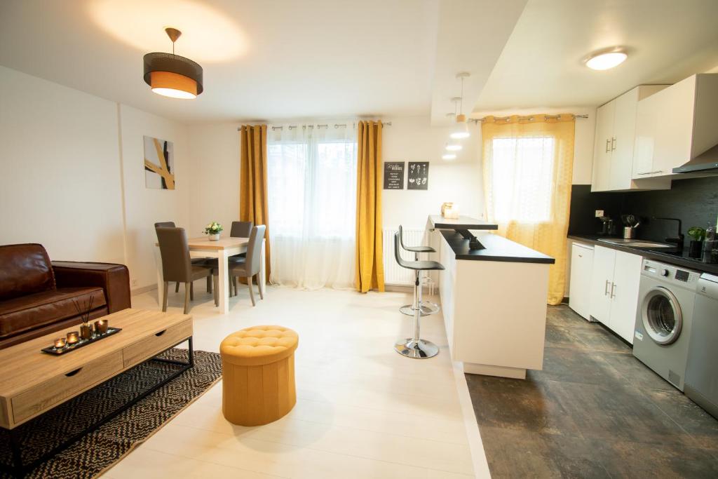 een keuken en een woonkamer met een bank en een tafel bij Le Joyau T2-55m2 Centre ville 10min Disney in Bussy-Saint-Georges