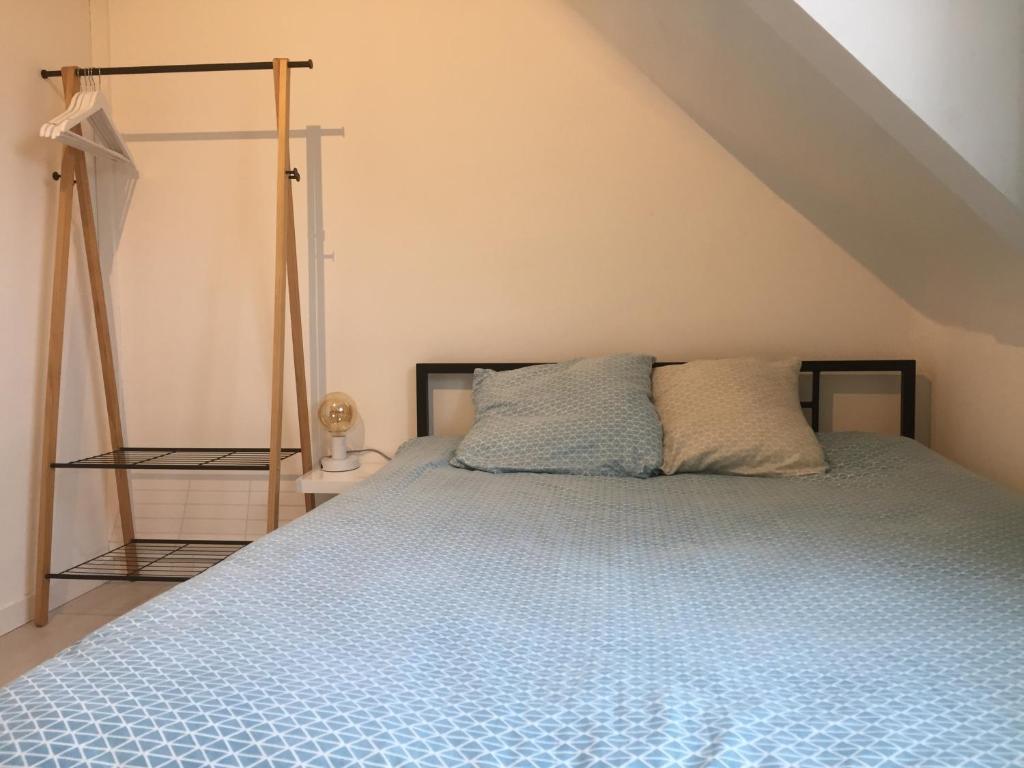 une chambre avec un lit avec une couette bleue dans l'établissement Studio 3 cosy au dernier étage, à Lorient
