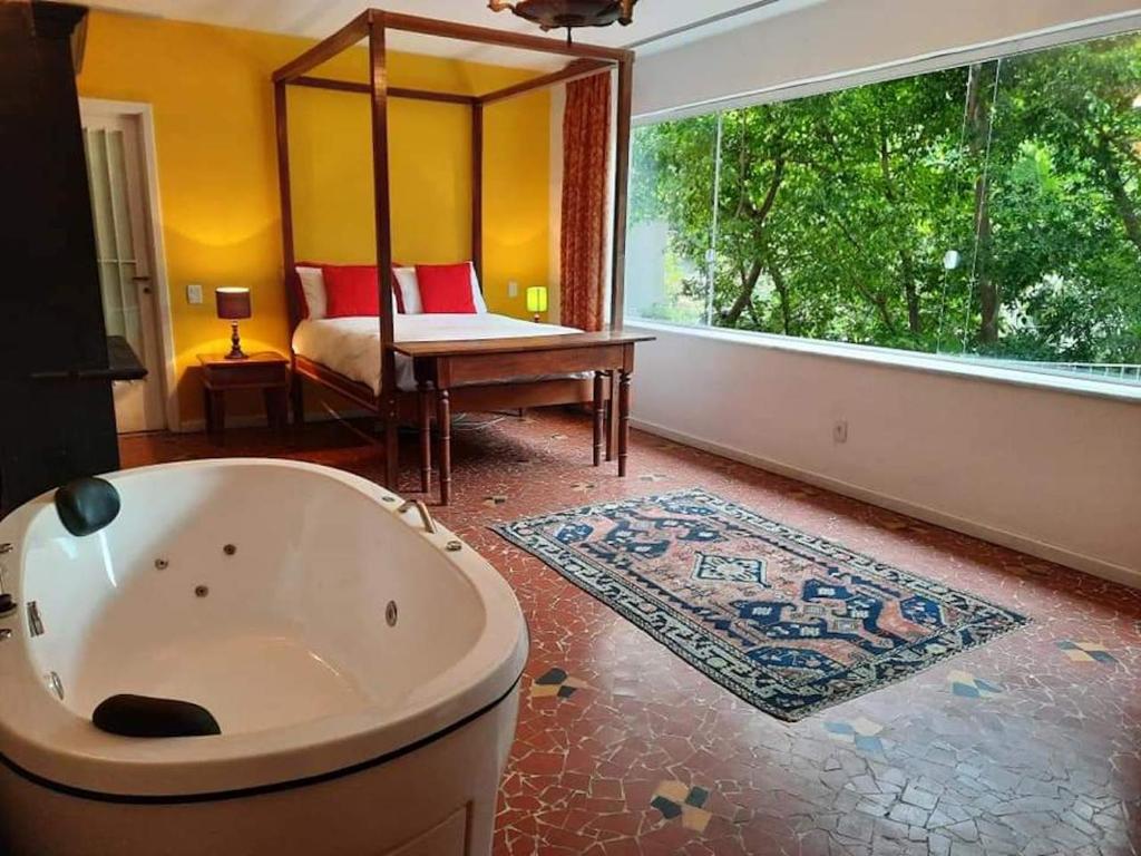 a large bathroom with a tub and a window at Rio Boutique Suites in Rio de Janeiro