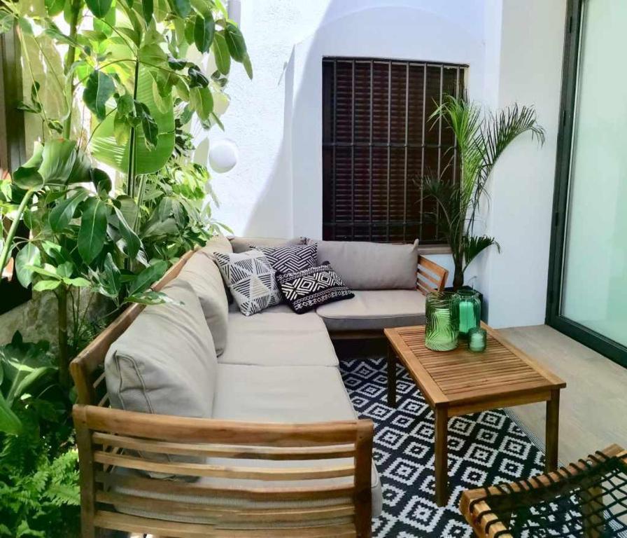 sala de estar con sofá, mesa y plantas en Casa Rural Albireo rebosante de luz y naturaleza, en Sanlúcar de Guadiana