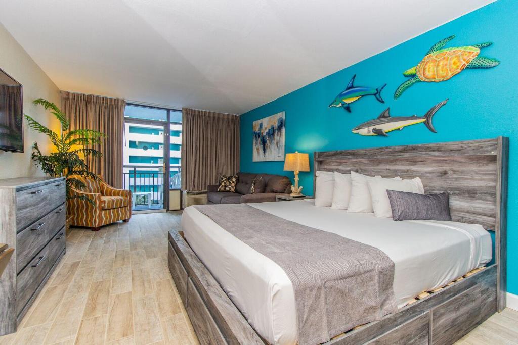 - une chambre avec un lit et un mur bleu dans l'établissement Landmark 618, à Myrtle Beach
