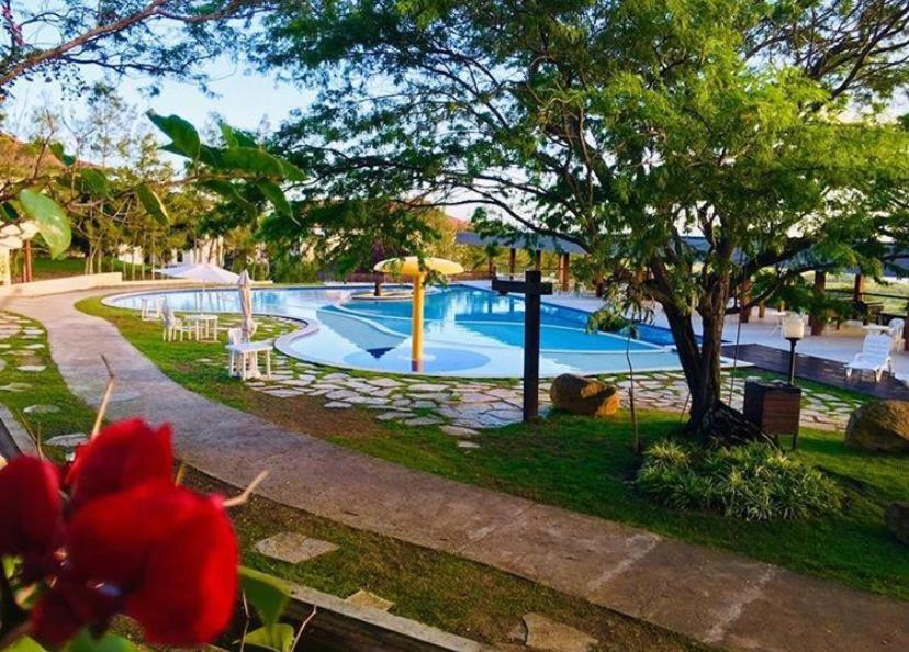 uma grande piscina num parque com uma flor vermelha em Flat Monte Castelo - Gravatá em Gravatá
