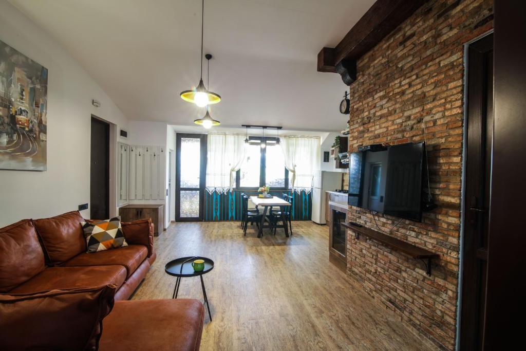 a living room with a couch and a brick wall at A lovely 2-bedroom apartment in central Tbilisi in Tbilisi City