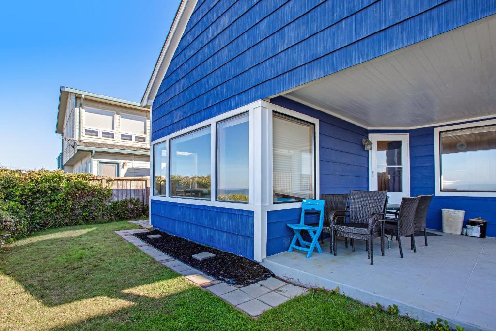 a blue house with a table and chairs in the yard at Coastal Serenity in Lincoln City