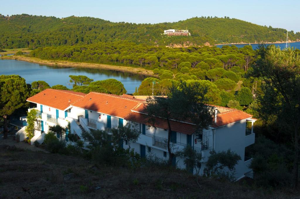 a house on a hill next to a lake at Aelia Studios in Koukounaries