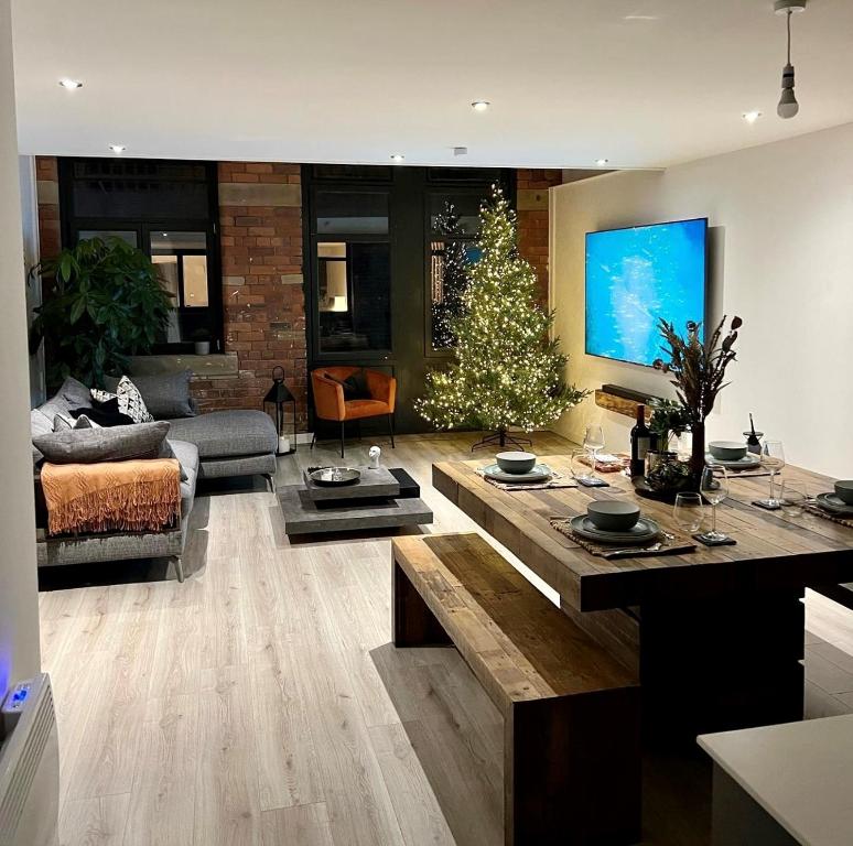 a living room with a christmas tree in it at EXCLUSIVE and MODERN - Bradford City Centre- 85" Cinema TV in Bradford