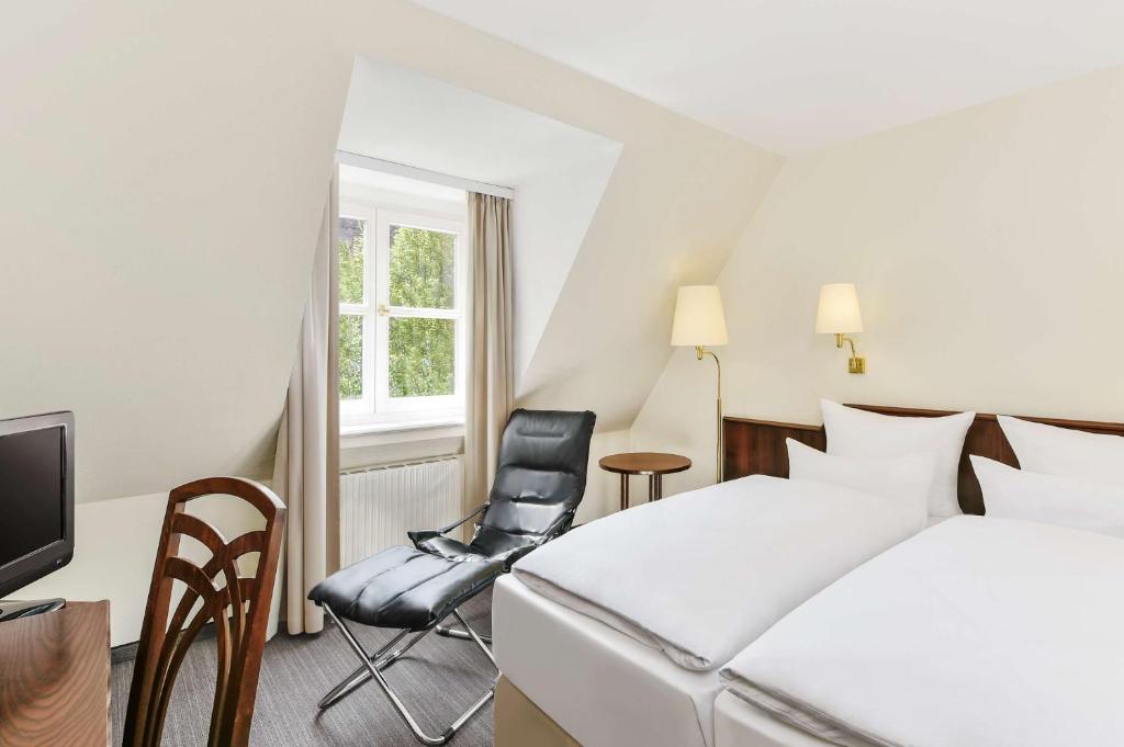 a hotel room with a bed and a chair at Hotel Klösterle Nördlingen in Nördlingen