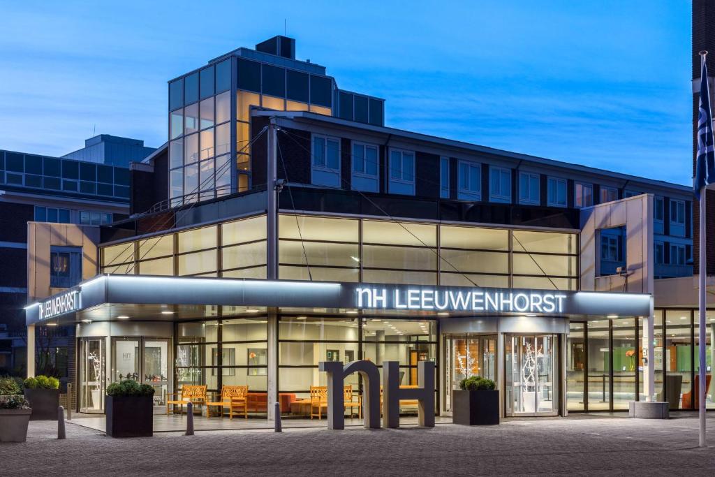 een gebouw met een bord ervoor bij NH Noordwijk Conference Centre Leeuwenhorst in Noordwijkerhout