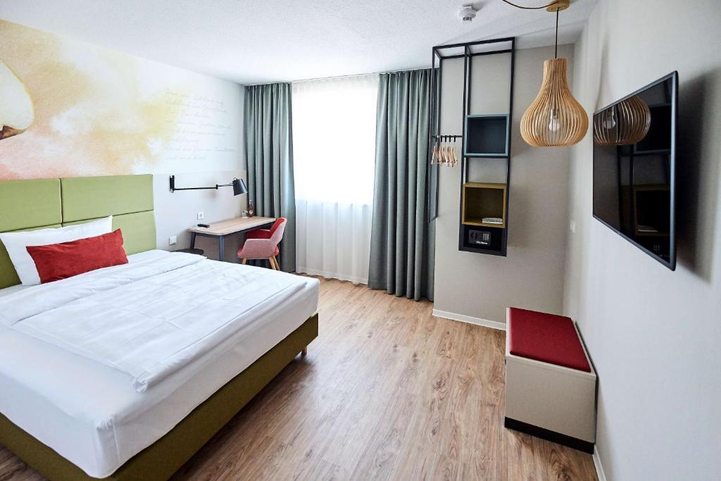 ein Schlafzimmer mit einem Bett und einem Schreibtisch in einem Zimmer in der Unterkunft Best Western Hotel Viernheim Mannheim in Viernheim
