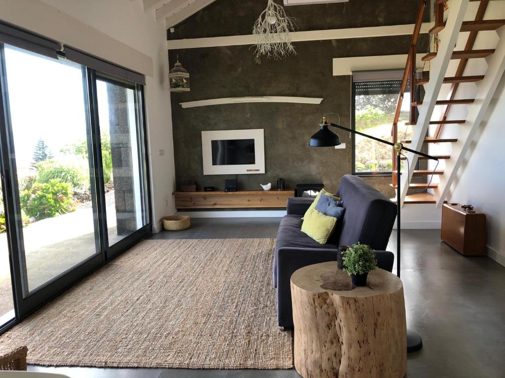 ein Wohnzimmer mit einem blauen Sofa und einem Tisch in der Unterkunft Casa da Arquinha in Santo Amaro