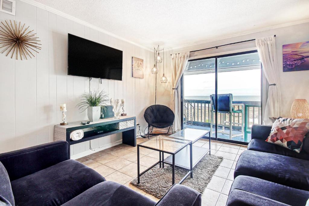 - un salon avec un canapé et une télévision dans l'établissement Cherry Grove Retreat & Sea Cabin, à Myrtle Beach