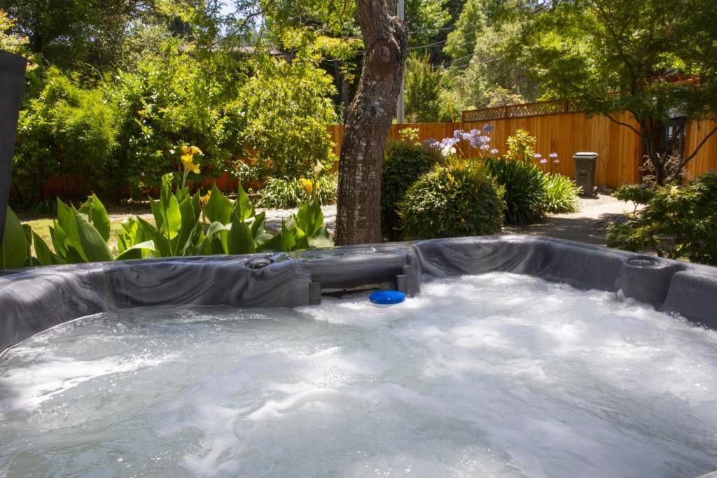 een grote hot tub in de tuin met bij Villa Mimosa Hot Tub Fire Table BBQ Walk to River Dog Friendly in Guerneville