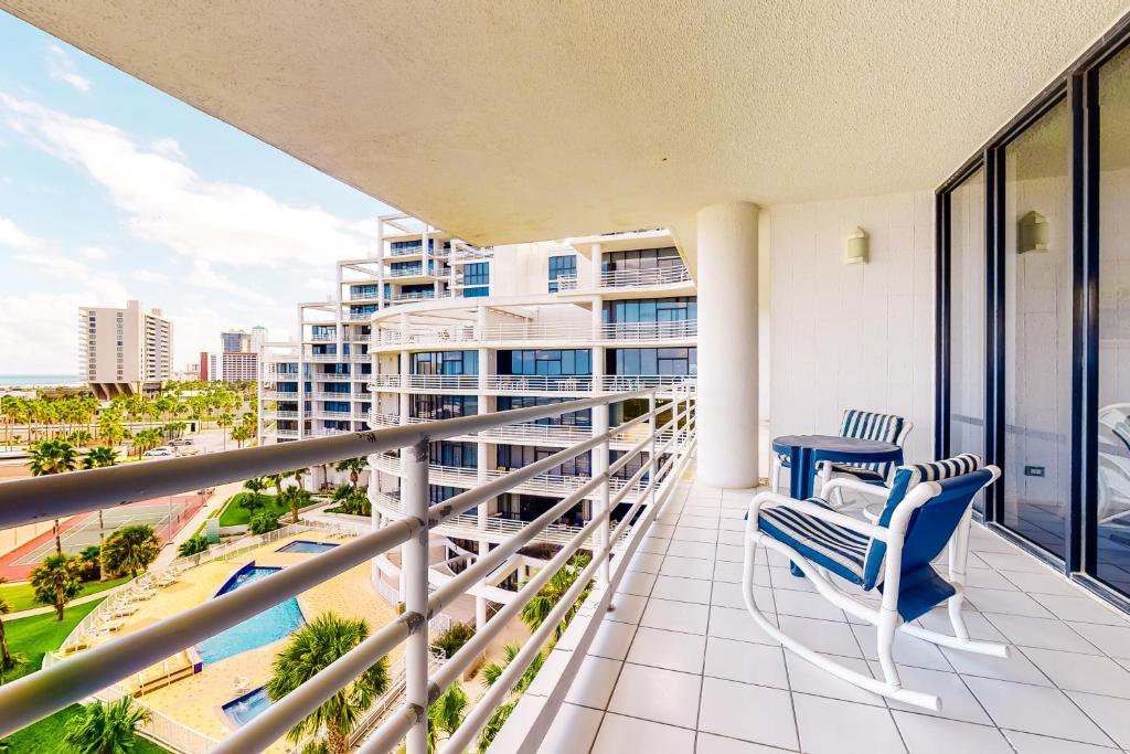 a balcony with two chairs and a view of a city at Sunchase IV in South Padre Island