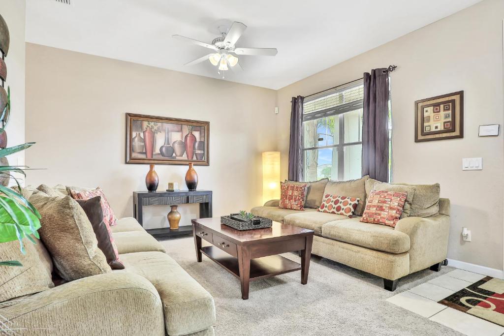 a living room with two couches and a table at Castle Street Memories in Kissimmee