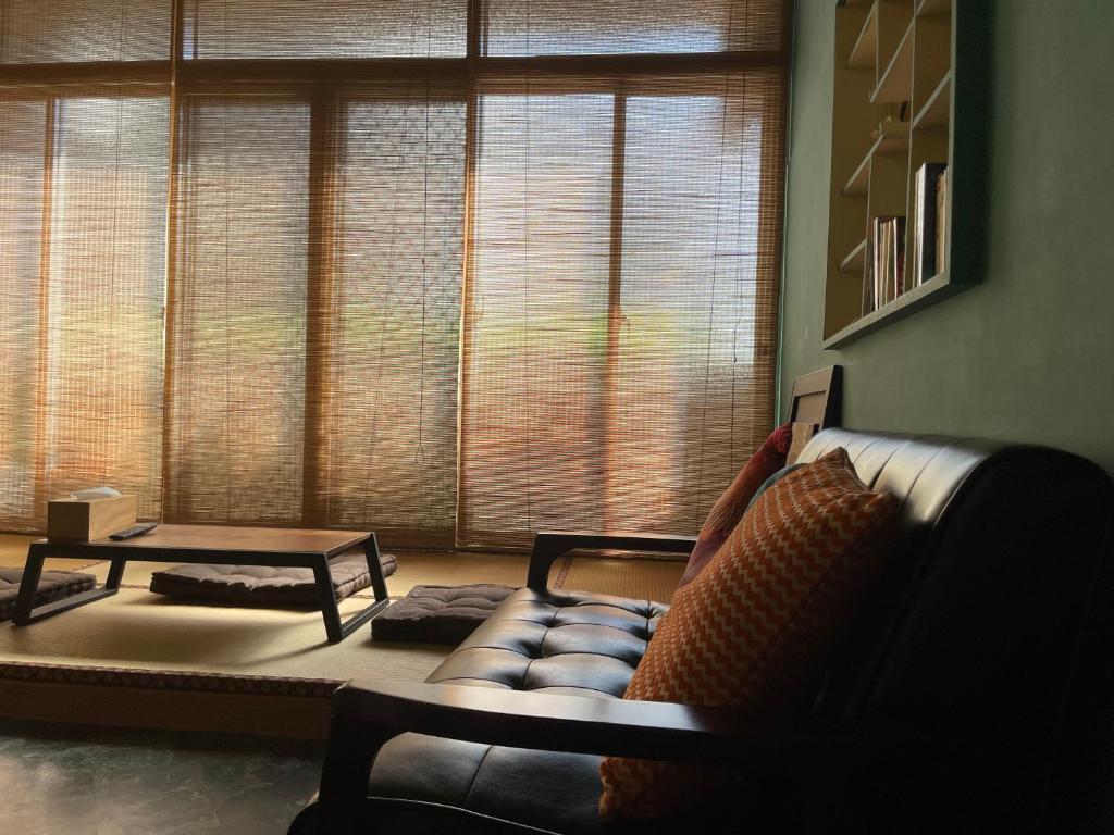 a living room with a couch and a large window at 米宿 Roomi House 台南老屋民宿 in Tainan