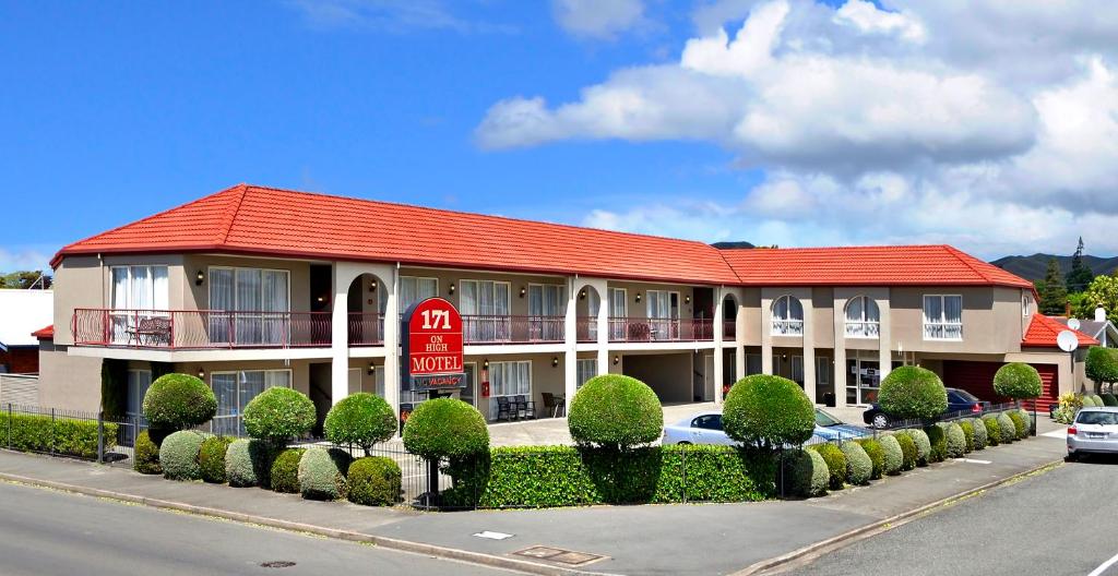 a hotel with a red roof on a street at 171 On High Motel in Blenheim