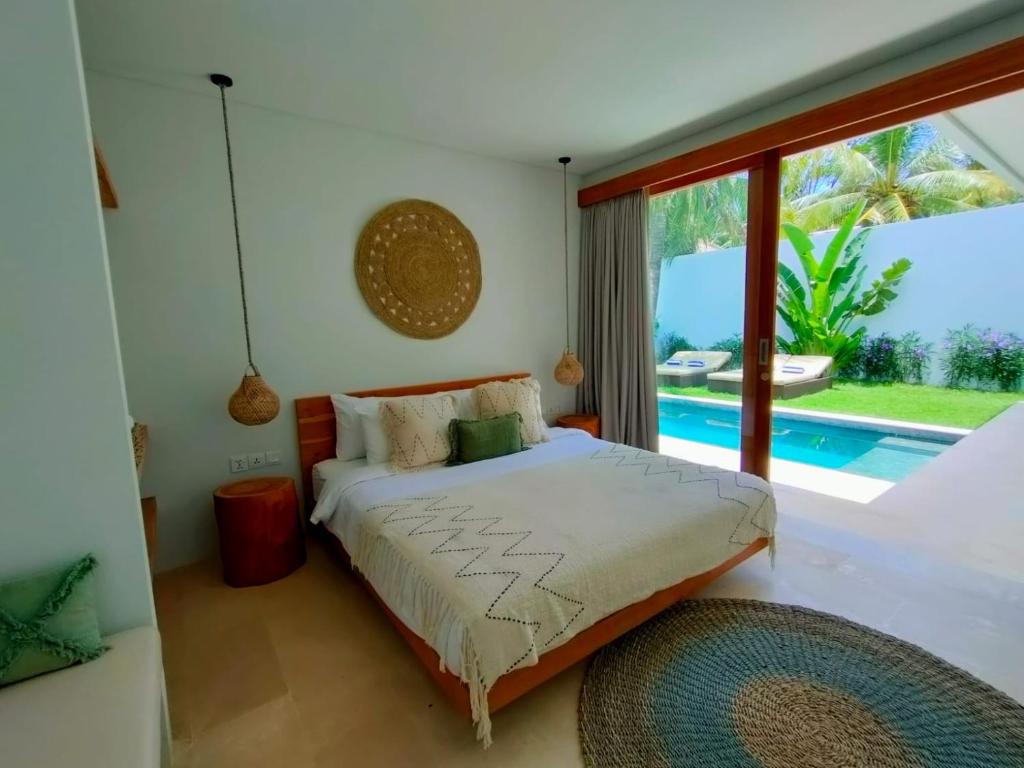a bedroom with a bed with a view of a pool at Kalea Villas in Kuta Lombok