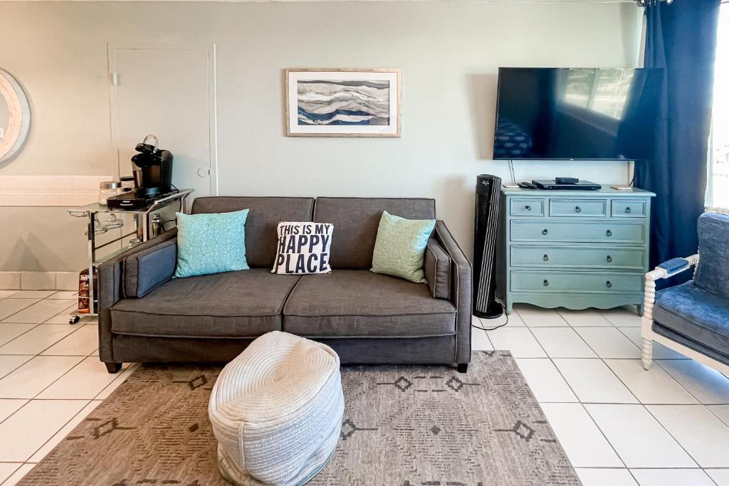 uma sala de estar com um sofá castanho e uma cómoda azul em Top of the Gulf 708 em Panama City Beach