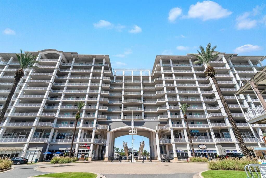 a large building with palm trees in front of it at The Wharf Condo with OASIS pool! in Orange Beach