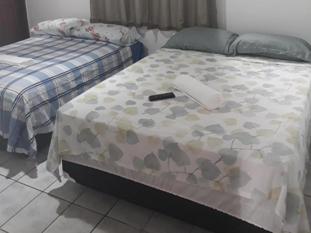 Un dormitorio con una cama con un teléfono. en HOTEL LATINOS 2, en Boa Vista