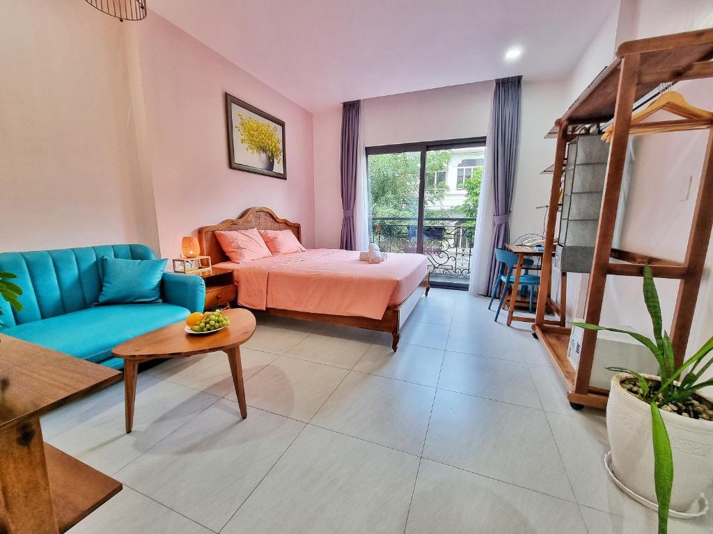 uma sala de estar com uma cama e um sofá azul em Mai Home - Apartment & Homestay em Ho Chi Minh
