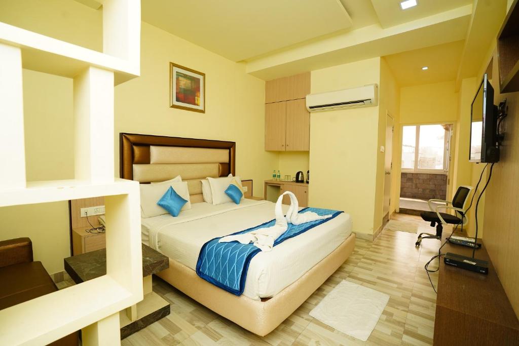 a bedroom with a bed and a television in it at Hotel SK Riverfront in Vijayawāda