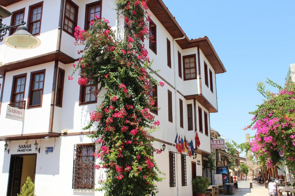 een gebouw met bloemen aan de zijkant bij Sabah Pension in Antalya