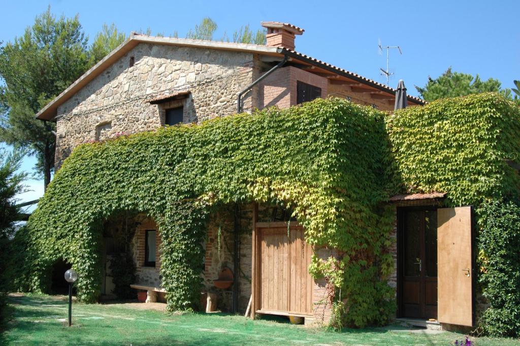 an ivy covered house with a wooden door at Podere Valmarina in Follonica