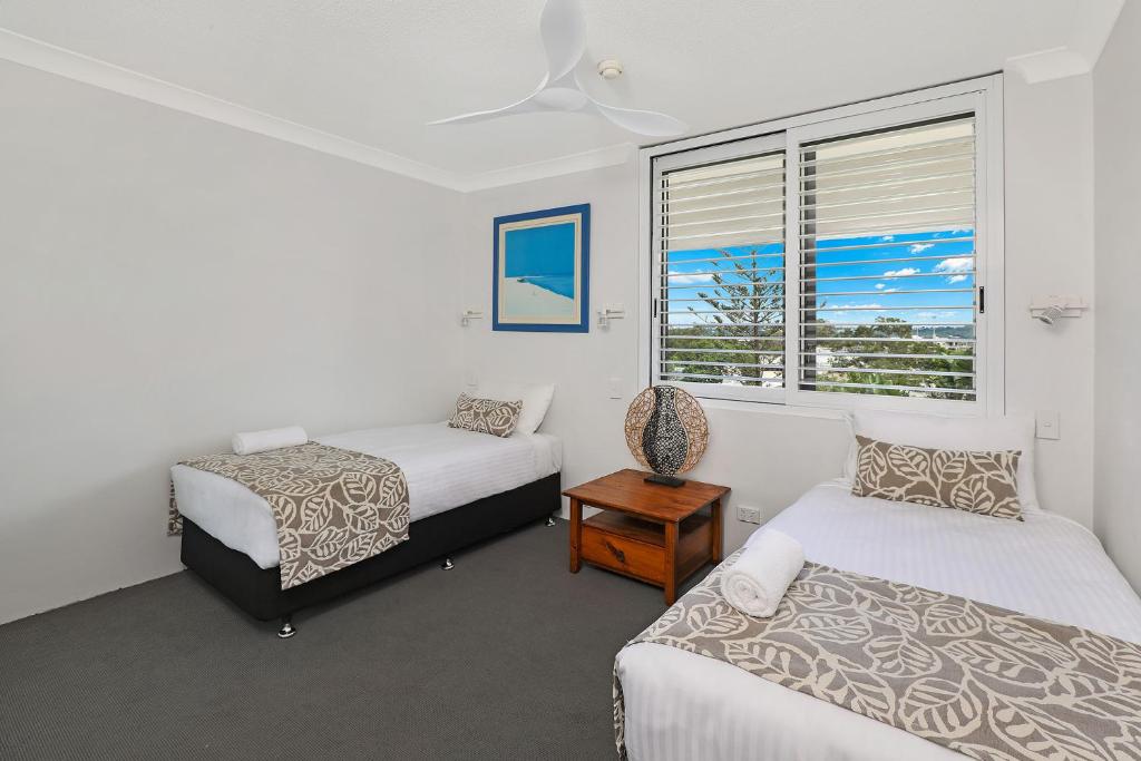 una camera da letto con due letti e una finestra di Majorca Isle Beachside Resort a Maroochydore