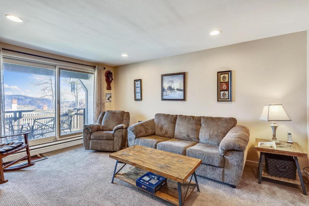 a living room with a couch and a chair and a table at Sunrise Timberline I7 in Killington