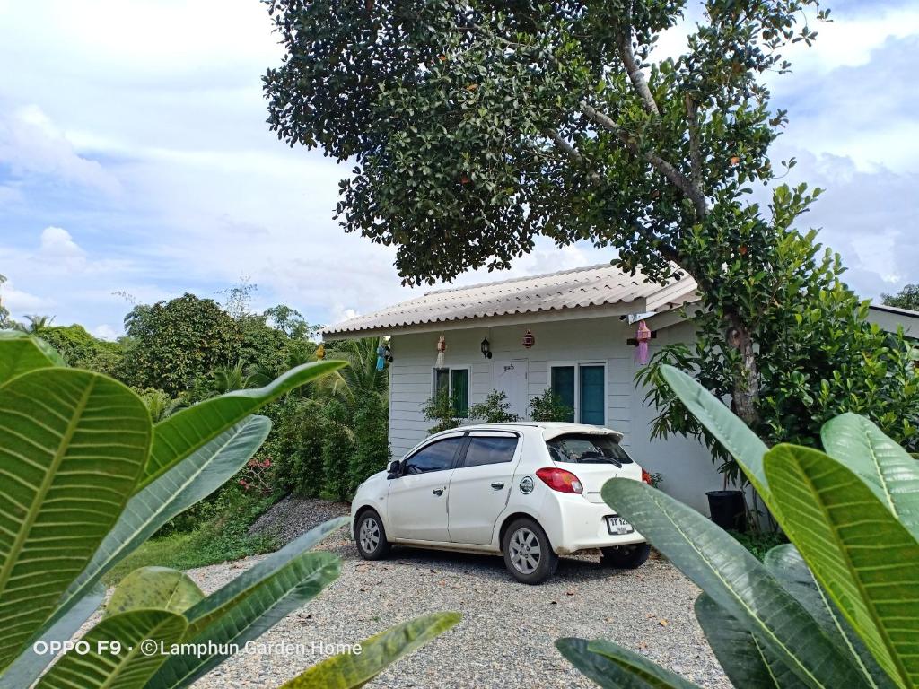una macchina bianca parcheggiata di fronte a una casa di Min Home a Lamphun